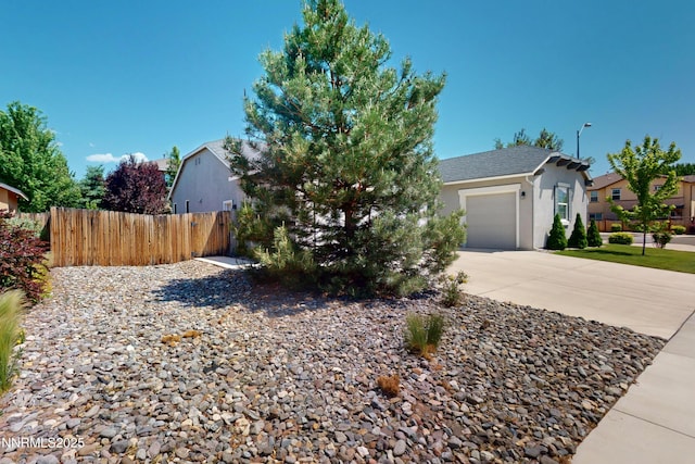 1509 Lasso Ln, Gardnerville, NV 89410 - view of front of house with stucco siding, driveway, an attached garage, and a residential view