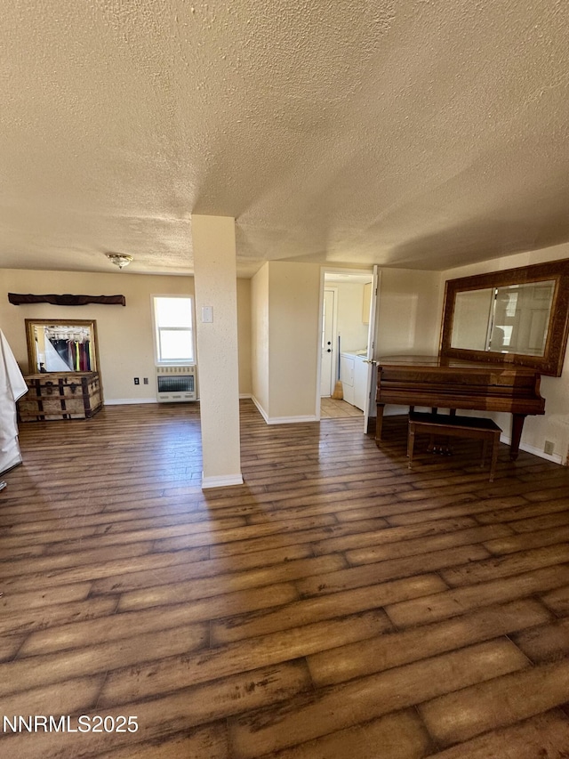13995 Grass Valley Rd, Winnemucca, NV 89445 - unfurnished living room with a textured ceiling, wood finished floors, baseboards, and heating unit