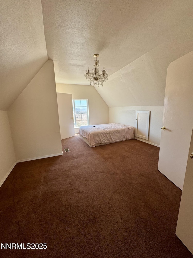 13995 Grass Valley Rd, Winnemucca, NV 89445 - unfurnished bedroom featuring carpet floors, lofted ceiling, a chandelier, and a textured ceiling