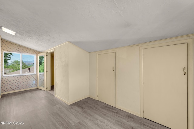 1480 Grandview Ave, Reno, NV 89503 - additional living space featuring light wood-type flooring, lofted ceiling, baseboards, and wallpapered walls