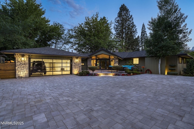 1180 Manzanita Ln, Reno, NV 89509 - view of front of house with an attached garage, stone siding, and decorative driveway