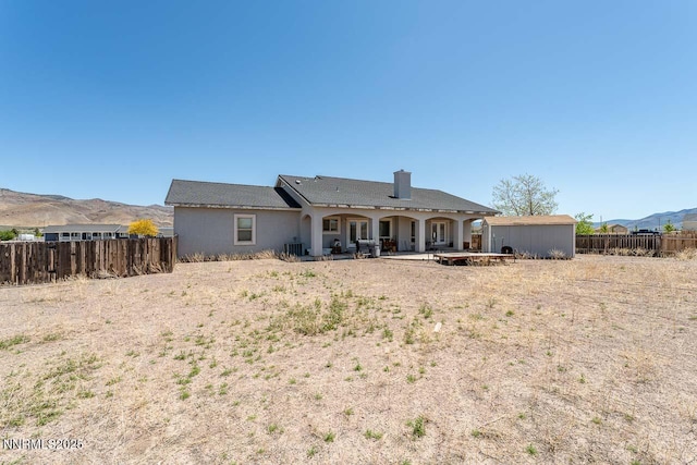 4945 Broken Spur Rd, Reno, NV 89510 - back of house with a patio area, a mountain view, a chimney, and an outdoor structure