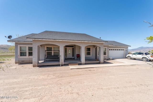 4945 Broken Spur Rd, Reno, NV 89510 - view of front facade featuring concrete driveway, covered porch, a garage, a mountain view, and stucco siding