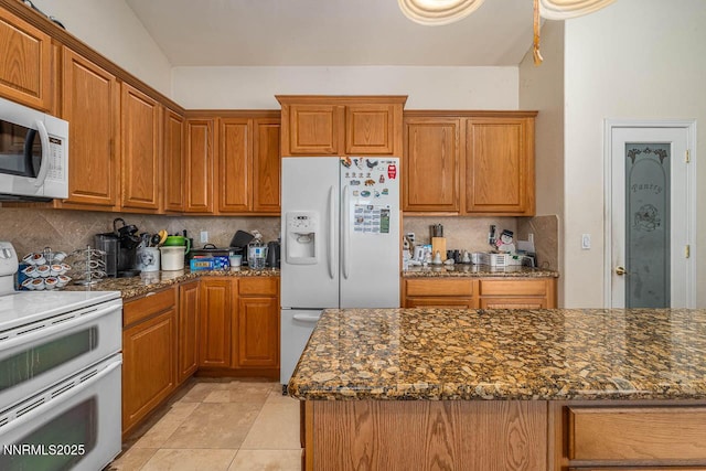 4945 Broken Spur Rd, Reno, NV 89510 - kitchen with white appliances, backsplash, and brown cabinetry