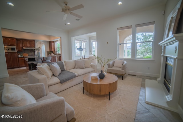 8270 Antler Pointe Ct, Reno, NV 89523 - living area with plenty of natural light, arched walkways, a glass covered fireplace, recessed lighting, and ceiling fan