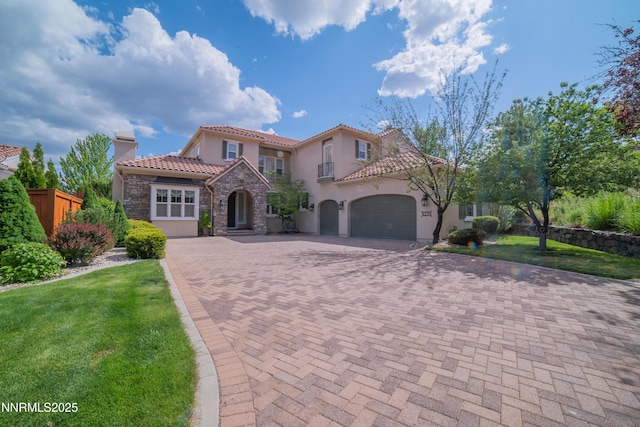 8270 Antler Pointe Ct, Reno, NV 89523 - mediterranean / spanish home featuring stone siding, decorative driveway, stucco siding, a tiled roof, and a garage