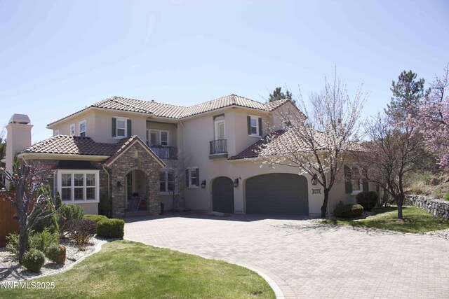 8270 Antler Pointe Ct, Reno, NV 89523 - mediterranean / spanish house with a balcony, a tiled roof, decorative driveway, and stucco siding