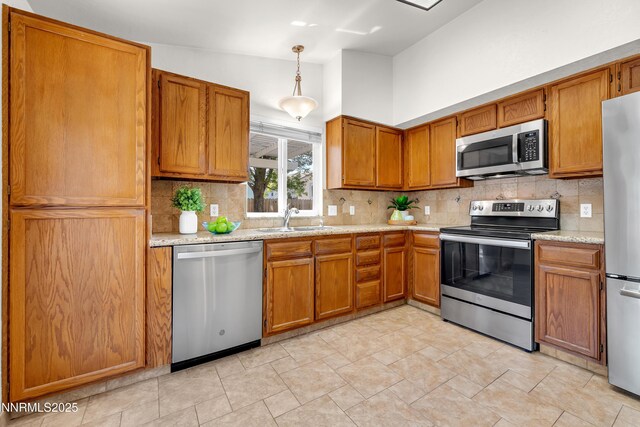 3353 Alpland Ln, Sparks, NV 89434 - kitchen featuring stainless steel appliances, decorative backsplash, brown cabinetry, pendant lighting, and vaulted ceiling