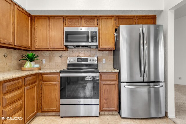 3353 Alpland Ln, Sparks, NV 89434 - kitchen featuring appliances with stainless steel finishes, decorative backsplash, brown cabinetry, and light stone counters