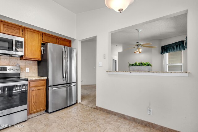 3353 Alpland Ln, Sparks, NV 89434 - kitchen with stainless steel appliances, ceiling fan, tasteful backsplash, and brown cabinetry