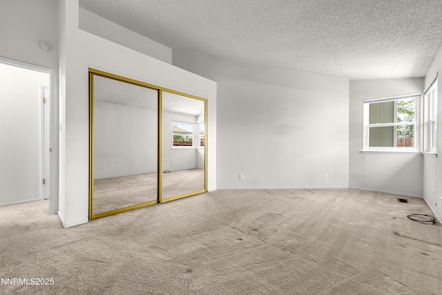 3353 Alpland Ln, Sparks, NV 89434 - unfurnished bedroom with carpet flooring, multiple windows, a textured ceiling, and a closet