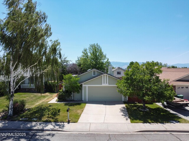 3353 Alpland Ln, Sparks, NV 89434 - view of property hidden behind natural elements with a garage, concrete driveway, a front yard, and a mountain view