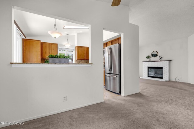 3353 Alpland Ln, Sparks, NV 89434 - kitchen featuring freestanding refrigerator, brown cabinets, light carpet, lofted ceiling, and hanging light fixtures