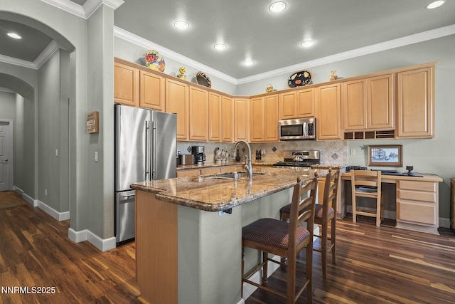 6694 Aston Cir, Sparks, NV 89436 - kitchen with appliances with stainless steel finishes, arched walkways, dark wood-style floors, light brown cabinets, and decorative backsplash