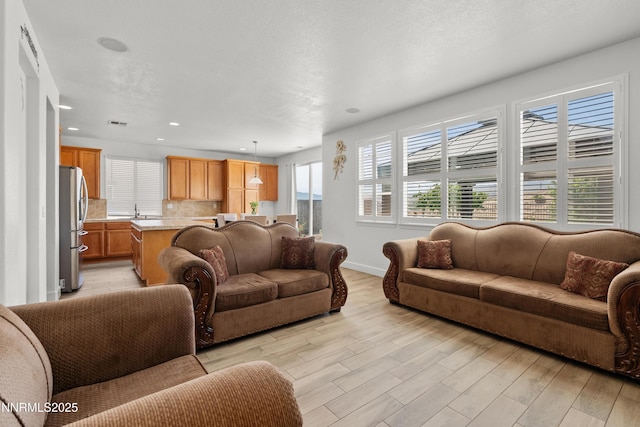 7935 Opal Station Dr, Reno, NV 89506 - living area featuring light wood-style floors, recessed lighting, and baseboards
