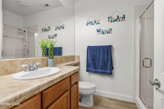 7935 Opal Station Dr, Reno, NV 89506 - bathroom featuring toilet, vanity, wood finished floors, a stall shower, and baseboards