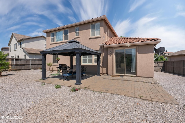 7935 Opal Station Dr, Reno, NV 89506 - rear view of property featuring a gazebo, stucco siding, a tile roof, a fenced backyard, and a patio