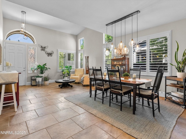1121 Sageberry Ct, Reno, NV 89509 - dining space featuring a chandelier, a towering ceiling, baseboards, and stone tile floors