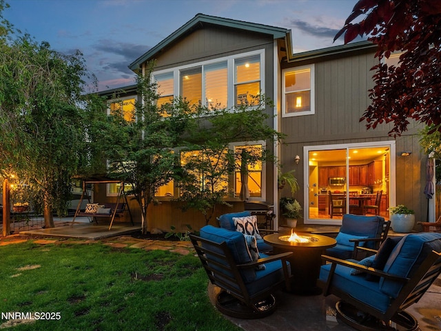 1121 Sageberry Ct, Reno, NV 89509 - back of property at dusk with an outdoor fire pit, a patio, and a lawn