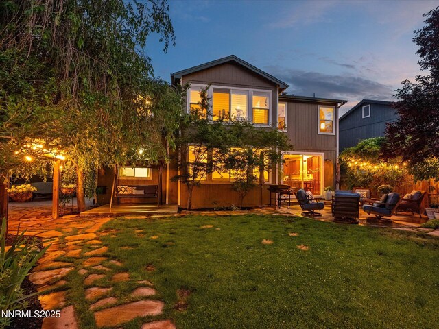 1121 Sageberry Ct, Reno, NV 89509 - back of property at dusk featuring an outdoor hangout area, a patio, and a yard