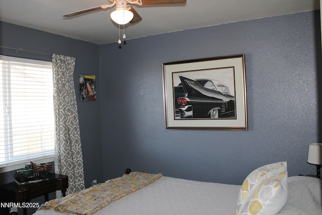 441 Dog Leg Dr, Fernley, NV 89408 - bedroom featuring multiple windows, a textured wall, and ceiling fan