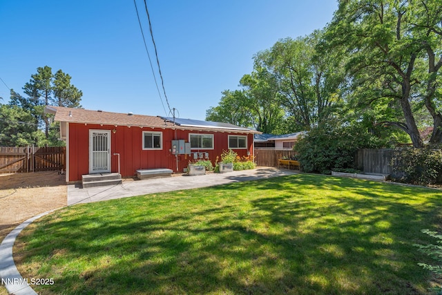 423 Bath St, Carson City, NV 89703 - rear view of house featuring board and batten siding, roof mounted solar panels, a patio, a fenced backyard, and entry steps