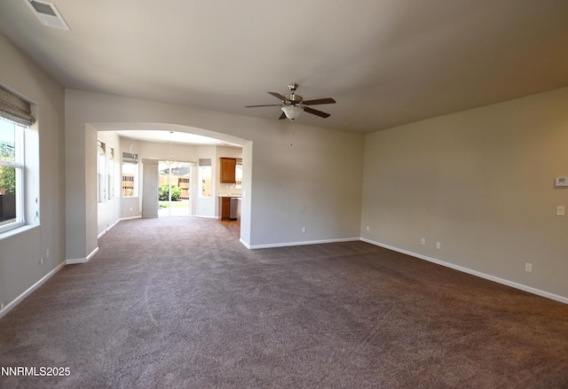 226 Red Oak Dr, Fernley, NV 89408 - unfurnished room featuring a ceiling fan, plenty of natural light, arched walkways, and dark carpet