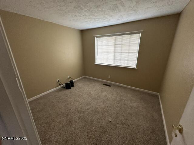 10083 Zeolite Dr, Reno, NV 89506 - carpeted spare room with a textured ceiling and baseboards
