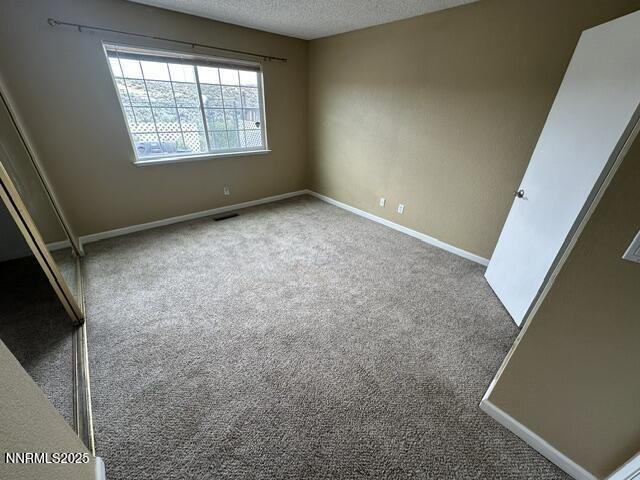 10083 Zeolite Dr, Reno, NV 89506 - unfurnished bedroom with carpet flooring and a textured ceiling
