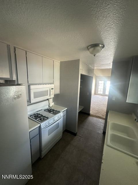 10083 Zeolite Dr, Reno, NV 89506 - kitchen with white appliances, a textured ceiling, and light countertops