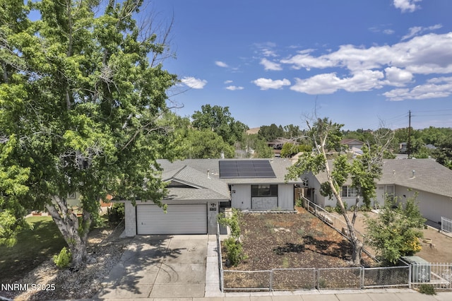 650 E York Way, Sparks, NV 89431 - view of front facade featuring a shingled roof, a fenced front yard, concrete driveway, solar panels, and a garage