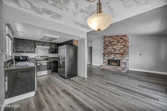 650 E York Way, Sparks, NV 89431 - kitchen with stainless steel appliances, light wood-type flooring, open floor plan, under cabinet range hood, and stone countertops