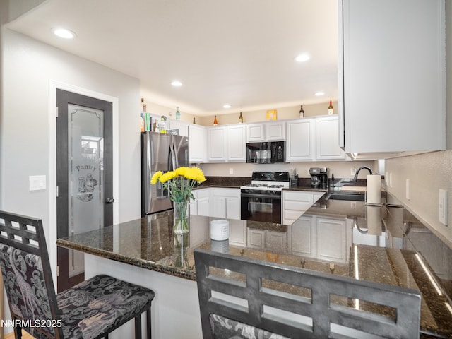 733 Bowles Ln, Gardnerville, NV 89460 - kitchen featuring white gas range oven, freestanding refrigerator, black microwave, a peninsula, and a sink