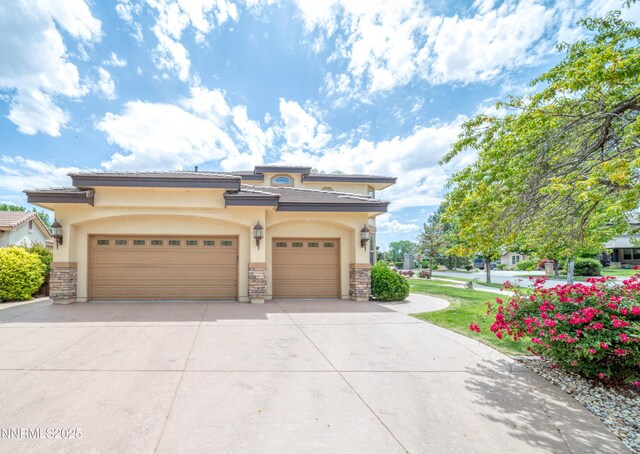 6752 Eagle Wing Cir, Sparks, NV 89436 - view of front of home with stucco siding, driveway, stone siding, and a garage