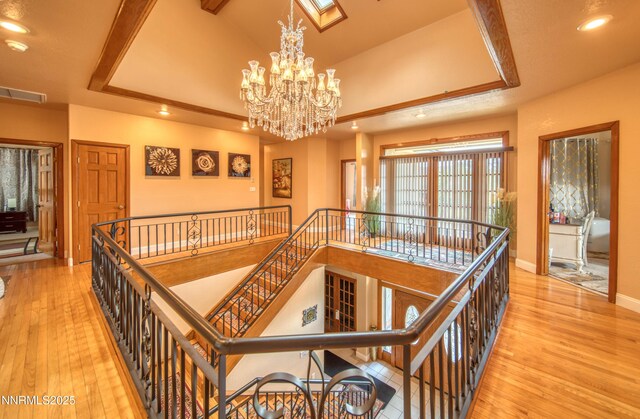 6752 Eagle Wing Cir, Sparks, NV 89436 - hallway featuring an upstairs landing, a chandelier, recessed lighting, hardwood / wood-style floors, and a tray ceiling
