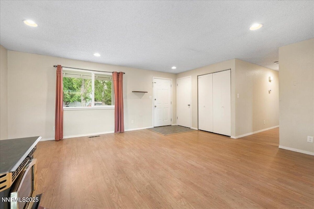 3830 Avocet Ct, Reno, NV 89508 - unfurnished living room featuring light wood-type flooring, a textured ceiling, and recessed lighting