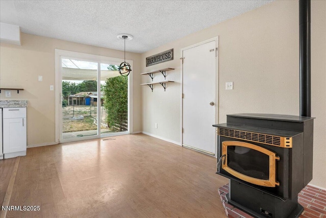 3830 Avocet Ct, Reno, NV 89508 - unfurnished living room with a wood stove, a textured ceiling, and wood finished floors