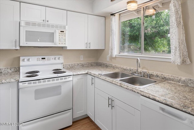3830 Avocet Ct, Reno, NV 89508 - kitchen with white appliances, white cabinetry, light countertops, and light wood-type flooring