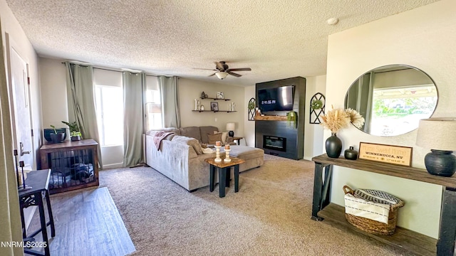 241 W National Ave, Winnemucca, NV 89445 - living area featuring ceiling fan, a textured ceiling, plenty of natural light, a fireplace, and carpet
