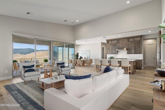 2241 Cold Creek Trl, Reno, NV 89523 - living area with light wood-type flooring, a mountain view, recessed lighting, and a towering ceiling