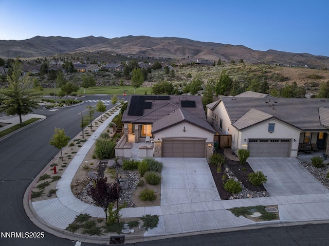 9195 Summertree Ct, Reno, NV 89523 - view of front of house with stucco siding, an attached garage, solar panels, and driveway