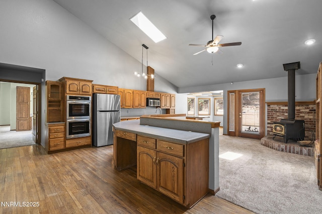 430 E Queen Way, Sparks, NV 89431 - kitchen featuring stainless steel appliances, a kitchen island, ceiling fan, high vaulted ceiling, and a wood stove
