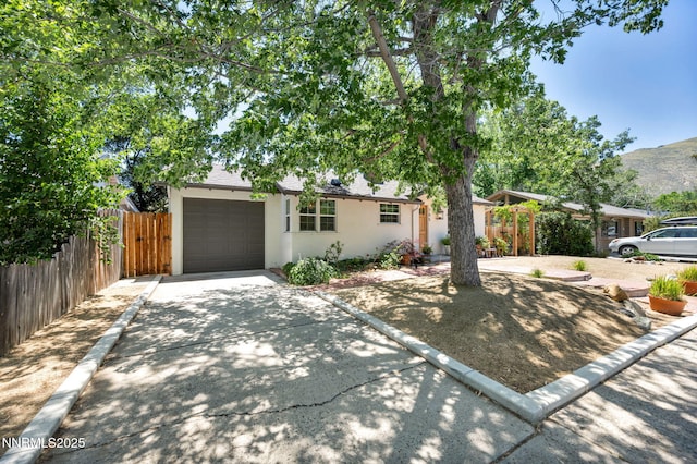 705 Elm St, Carson City, NV 89703 - view of front of property with stucco siding, concrete driveway, a garage, and a mountain view
