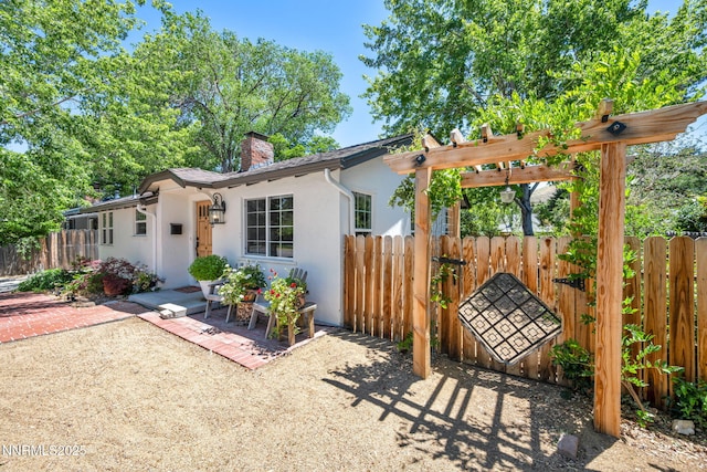705 Elm St, Carson City, NV 89703 - view of front facade with stucco siding, a chimney, a patio area, and a pergola
