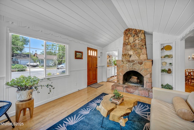705 Elm St, Carson City, NV 89703 - living room featuring wooden ceiling, light wood-type flooring, vaulted ceiling, a stone fireplace, and wainscoting
