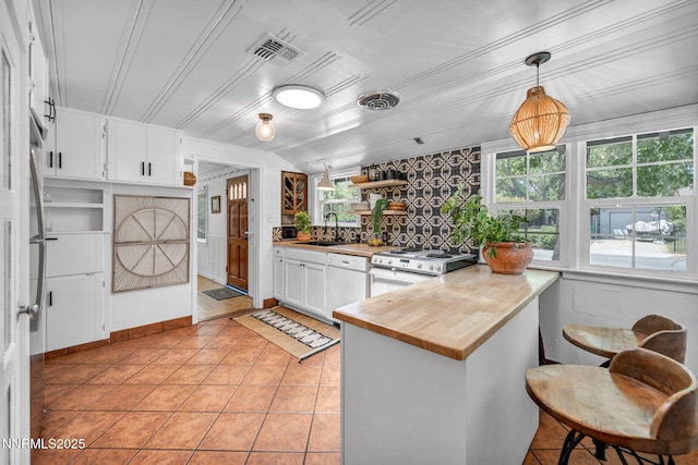 705 Elm St, Carson City, NV 89703 - kitchen with open shelves, a peninsula, white cabinets, electric range, and light tile patterned flooring