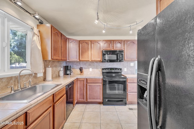 3310 Delna Dr, Sparks, NV 89431 - kitchen featuring black appliances, decorative backsplash, light tile patterned floors, brown cabinets, and tile counters