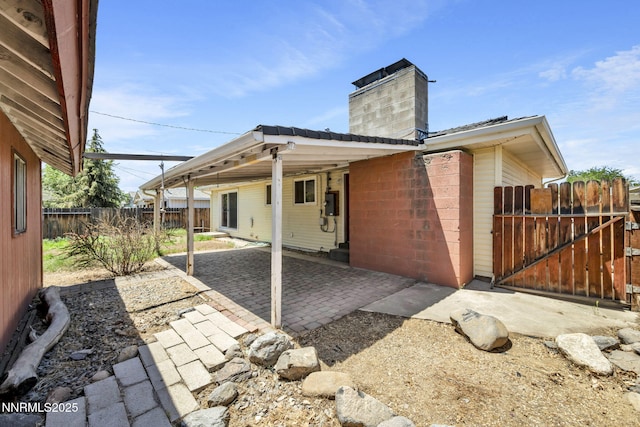 3310 Delna Dr, Sparks, NV 89431 - back of property featuring concrete block siding, a chimney, a patio area, and a gate