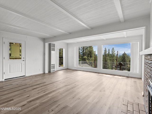 605 Jerry Dr, Zephyr Cove, NV 89448 - unfurnished living room featuring beamed ceiling, a stone fireplace, plenty of natural light, wood finished floors, and heating unit