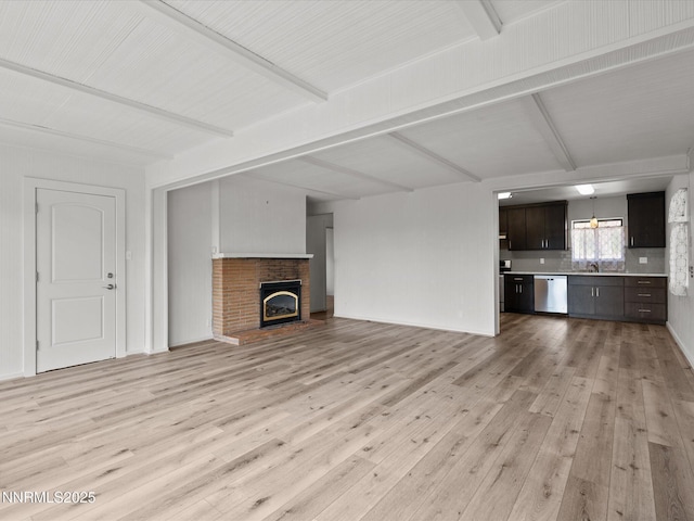 605 Jerry Dr, Zephyr Cove, NV 89448 - unfurnished living room featuring light wood-style floors, a sink, beam ceiling, and a fireplace